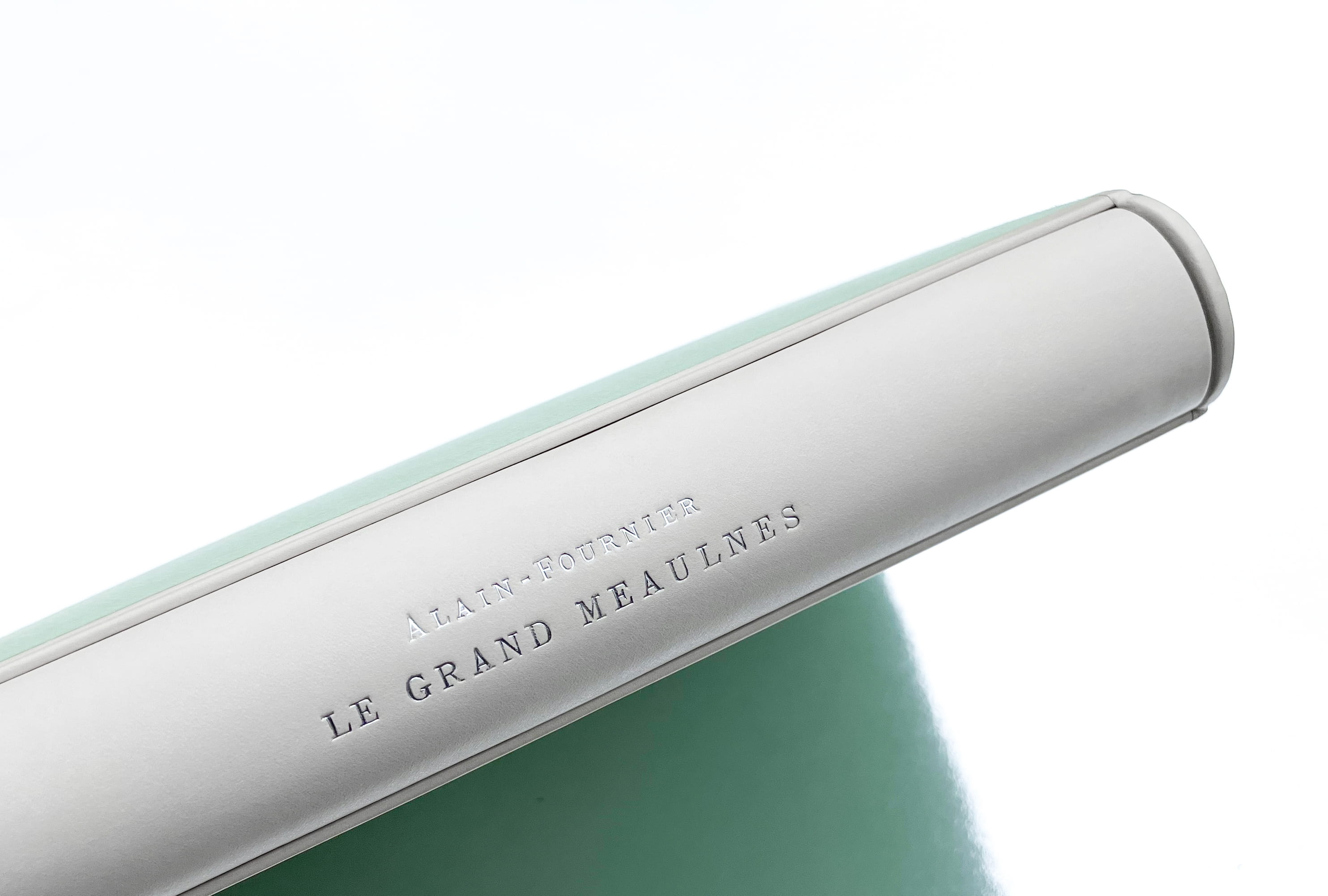 Vue sur le dos de la chemise, le titre est marqué à chaud avec un film argenté