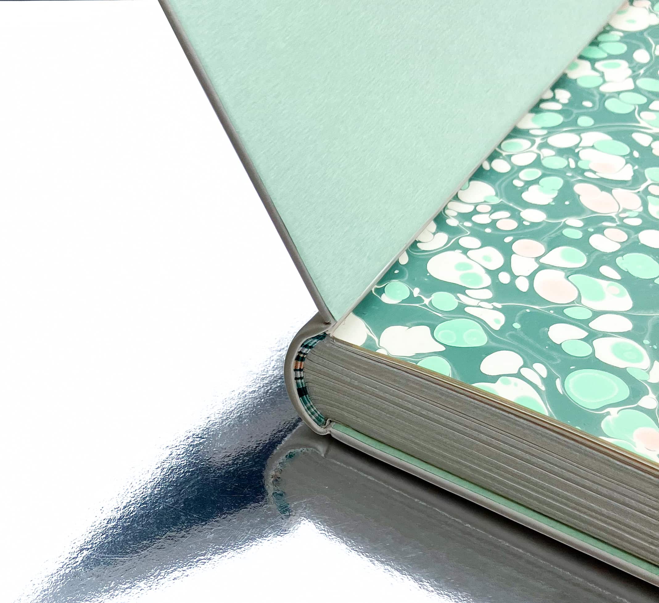 Vue sur la tranchefiles brodées, la coiffe, les fardes bords à bords et la garde volante en papier marbré