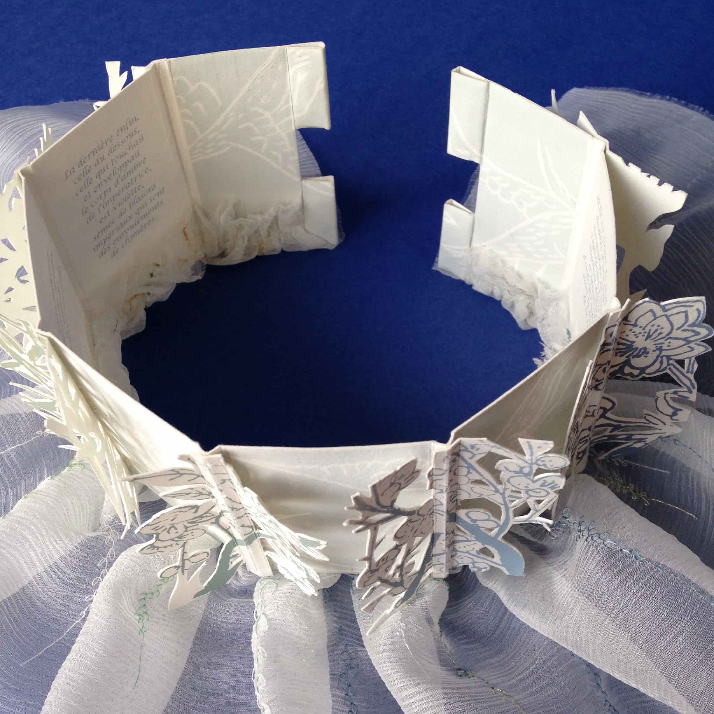 Livre d'artiste composé de papiers découpés, sérigraphiés et d'une partie textile en soie brodée. Une grande bande de papier assemble le tout, le texte est imprimé sur le verso.