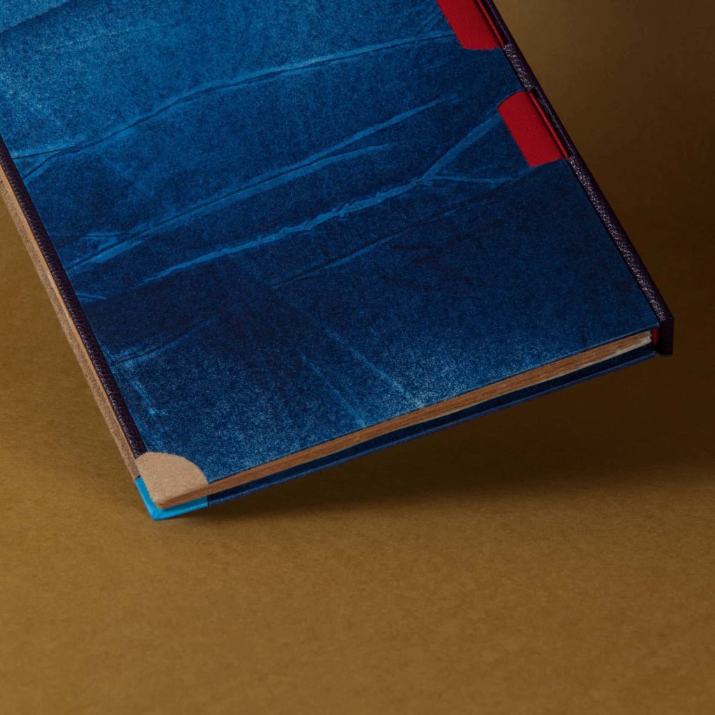 Vue sur les détails : coins en cuir de nubuck camel, impression du papier dans un camaïeu de bleu